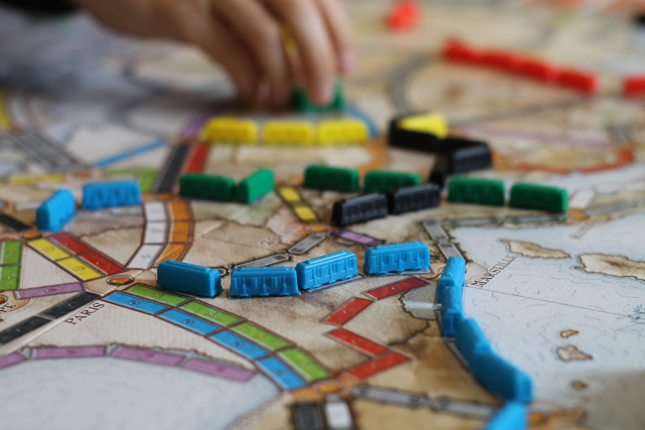 Player placing a train car on a Ticket to Ride game board in the middle of a game