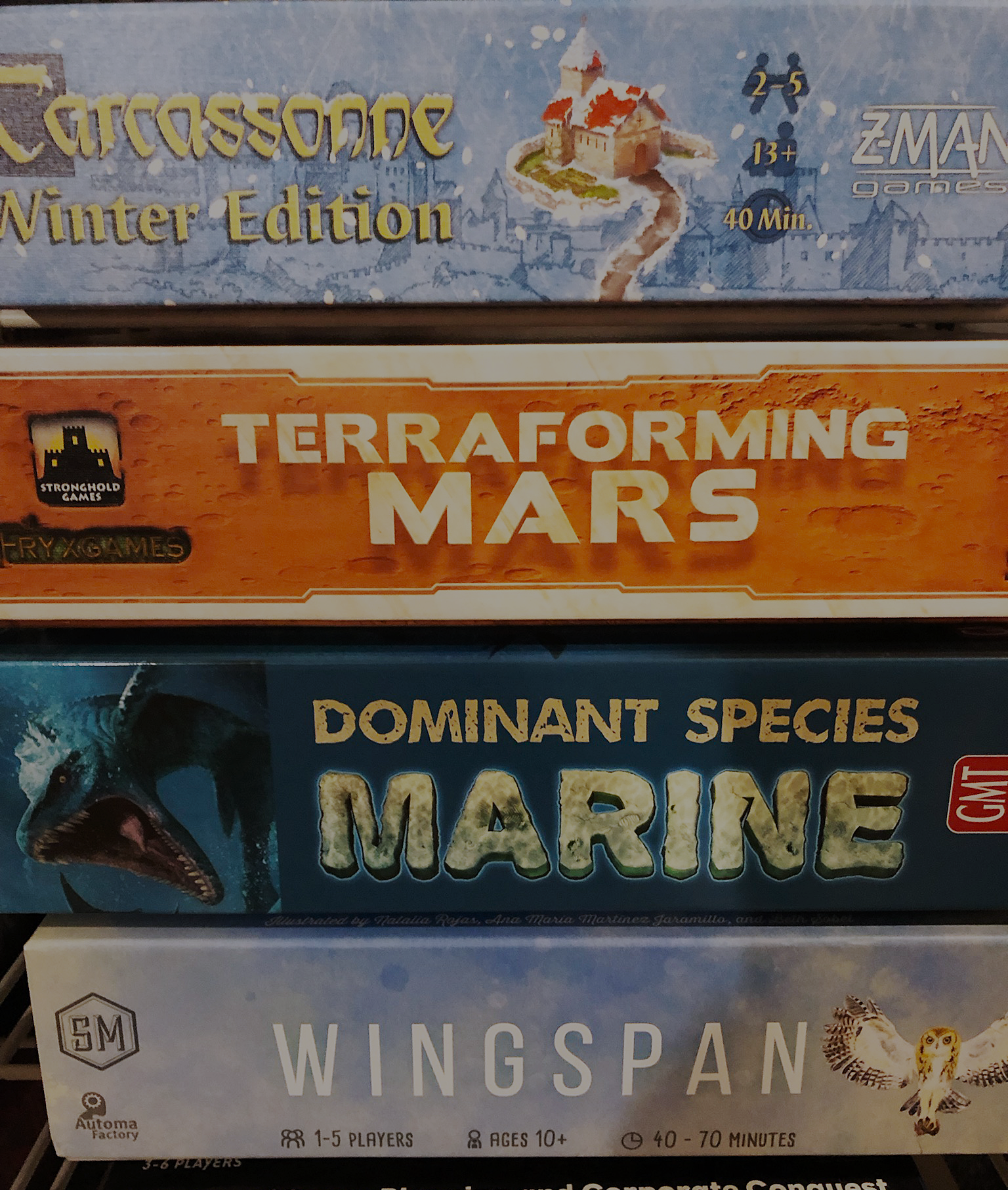 Carcassonne, Terraforming Mars, Dominant Species: Marine, Wingspan and Acquire board game boxes stacked